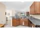 Kitchen with granite counters, wood cabinets, and view of living area at 13488 Abercrombie Dr, Englewood, FL 34223