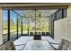 Relaxing screened lanai with seating area and view of lush greenery at 13488 Abercrombie Dr, Englewood, FL 34223