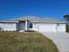 Single-story home with a two-car garage and a well-manicured lawn at 14331 Montmarte Ave, Port Charlotte, FL 33981