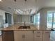 Granite-topped kitchen island with stainless sink overlooks the living area and pool at 14331 Montmarte Ave, Port Charlotte, FL 33981