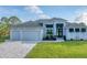 Modern home with three-car garage and manicured lawn at 14351 Howard Ave, Port Charlotte, FL 33953