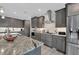 Modern kitchen featuring gray cabinets, granite countertops, and a stainless steel range hood at 14351 Howard Ave, Port Charlotte, FL 33953