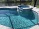 Relaxing pool and spa with water feature, surrounded by a tiled deck at 14351 Howard Ave, Port Charlotte, FL 33953