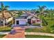 Single-story home with a brick driveway, two palm trees, and a lush lawn at 2148 La Palma Ave, Port Charlotte, FL 33953