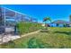 Landscaped backyard with lush greenery and a screened pool area at 2148 La Palma Ave, Port Charlotte, FL 33953