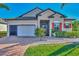 One-story house with orange shutters, a white garage door, and landscaping at 2148 La Palma Ave, Port Charlotte, FL 33953