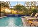 Relaxing screened pool with waterfall feature and lush landscaping at 27441 Hole In One Pl, Englewood, FL 34223