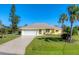 Bright yellow house with a neatly landscaped yard and a two-car garage at 3016 Montgomery Dr, Port Charlotte, FL 33981