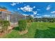 Spacious backyard with lush lawn, screened pool, and water views at 3300 Pennyroyal Rd, Port Charlotte, FL 33953