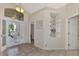 Bright and airy foyer with tile flooring and built-in shelving at 3300 Pennyroyal Rd, Port Charlotte, FL 33953