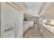Long kitchen with white appliances, view of backyard, and tiled floors at 3300 Pennyroyal Rd, Port Charlotte, FL 33953