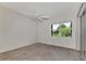 Bright bedroom with ceiling fan, large window, and wood-look flooring at 3392 Pennyroyal Rd, Port Charlotte, FL 33953