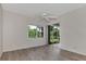 Bedroom with sliding door to patio, ceiling fan, and light wood-look floors at 3392 Pennyroyal Rd, Port Charlotte, FL 33953