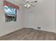 Bright bedroom with ceiling fan, window, and grey tile floor at 3392 Pennyroyal Rd, Port Charlotte, FL 33953