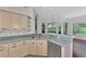 Bright kitchen with ample cabinetry, dual sink, and view to backyard at 3392 Pennyroyal Rd, Port Charlotte, FL 33953