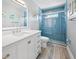 Modern bathroom with blue tile shower and white vanity at 4639 Kempson Ln, Port Charlotte, FL 33981