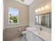 Modern bathroom with white cabinets, quartz countertop, and updated fixtures at 10030 Eagle Preserve Dr, Englewood, FL 34224