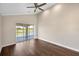 Spacious bedroom with hardwood floors and sliding glass doors to a private balcony overlooking the golf course at 10030 Eagle Preserve Dr, Englewood, FL 34224