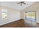 Bright bedroom with hardwood floors and sliding glass doors leading to a private balcony with golf course views at 10030 Eagle Preserve Dr, Englewood, FL 34224