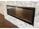 Modern linear fireplace with a stone surround at 10030 Eagle Preserve Dr, Englewood, FL 34224