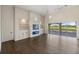 Spacious living room featuring a stone fireplace and built-in shelving, with access to a patio overlooking a golf course at 10030 Eagle Preserve Dr, Englewood, FL 34224