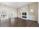 Open living room with hardwood floors, a stone fireplace and built-in shelving, and views to the entryway at 10030 Eagle Preserve Dr, Englewood, FL 34224
