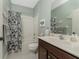 Clean bathroom with a shower/tub combo and wood vanity at 11249 Mc Dermott Ct, Englewood, FL 34223