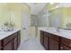 Large bathroom with double vanity, shower, and yellow walls at 11249 Mc Dermott Ct, Englewood, FL 34223