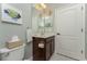 Well-lit bathroom with a single sink vanity and toilet at 11249 Mc Dermott Ct, Englewood, FL 34223