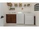 Laundry room with washer, dryer, and ample storage shelving at 11249 Mc Dermott Ct, Englewood, FL 34223