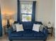 Cozy living room featuring a blue sofa and two end tables at 11249 Mc Dermott Ct, Englewood, FL 34223