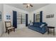 Bright living room with a blue sofa and ample natural light at 11249 Mc Dermott Ct, Englewood, FL 34223