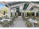 Outdoor patio with white tables and green chairs under a covered structure at 11249 Mc Dermott Ct, Englewood, FL 34223