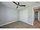 Cozy bedroom with ceiling fan, wood-look floors, and double doors to closet at 1131 Boundary Blvd, Rotonda West, FL 33947