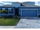 Two-story home with blue exterior, three-car garage, and landscaping at 16383 S Port Harbor Blvd, Port Charlotte, FL 33953
