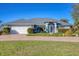 Single-story home with a two-car garage and nicely landscaped lawn at 2 Broadmoor Rd, Rotonda West, FL 33947