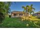 Large backyard with grassy area, screened patio, and palm trees at 2 Marker Rd, Rotonda West, FL 33947