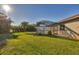 Screened patio and expansive grassy backyard with tropical landscaping at 2 Marker Rd, Rotonda West, FL 33947