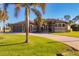 Single-Gathering home exterior featuring a three-car garage and palm trees at 2 Marker Rd, Rotonda West, FL 33947