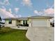 One-story house with a gray metal roof, white garage door, and well-manicured lawn at 2673 Titania Rd, Englewood, FL 34224