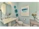 Elegant bathroom with a pedestal sink and decorative art at 26790 Weiskopf Dr, Englewood, FL 34223