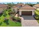 Single-story home with tile roof, landscaping, and a paved driveway at 26790 Weiskopf Dr, Englewood, FL 34223