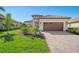 Single story house with tile roof, landscaping and paved driveway at 26790 Weiskopf Dr, Englewood, FL 34223