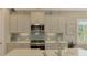 Modern kitchen with stainless steel appliances and light gray cabinets at 26790 Weiskopf Dr, Englewood, FL 34223