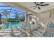 Covered patio with pool view and dining table at 26790 Weiskopf Dr, Englewood, FL 34223