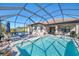 Inviting pool and patio area with covered lanai, comfortable seating, and grilling space at 26790 Weiskopf Dr, Englewood, FL 34223