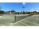 Well-maintained tennis court with surrounding fencing and seating area at 26790 Weiskopf Dr, Englewood, FL 34223
