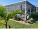 Landscaped backyard showcasing a screened patio area at 3090 Lockwood St, Port Charlotte, FL 33952