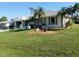 Single-story home with green accents, palm trees, and well-maintained lawn at 3090 Lockwood St, Port Charlotte, FL 33952