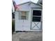White storage shed with green trim and an American flag at 3090 Lockwood St, Port Charlotte, FL 33952
